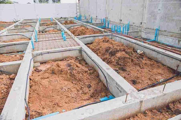 Concrete foundation installation with footing layout and plumbing lines prepared for residential build in Medina, OH