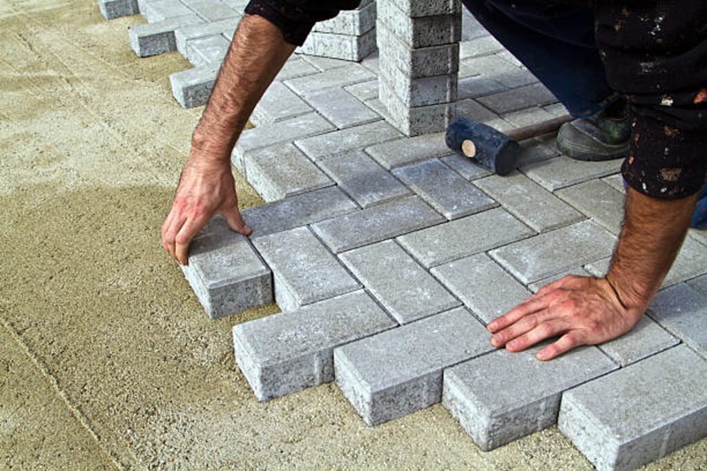 Contractor installing concrete pavers for patio construction on a compacted base in Medina, OH