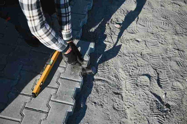 Stamped concrete installation with worker shaping and finishing textured surface in North Ridgeville, OH