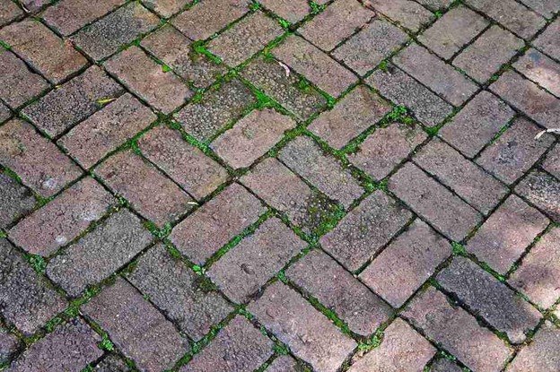Uneven patio surface with shifting pavers and gaps before concrete patio replacement in Medina, OH